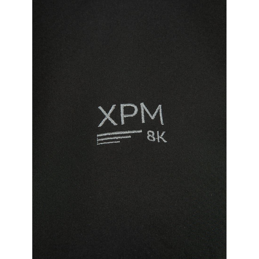 תקריב של בד שחור שעליו רקום בטקסט לבן "Puffin X" מאת Aztec ו-"XPM" מעל שלוש קווים אופקיים, עם "8K" מימין.
