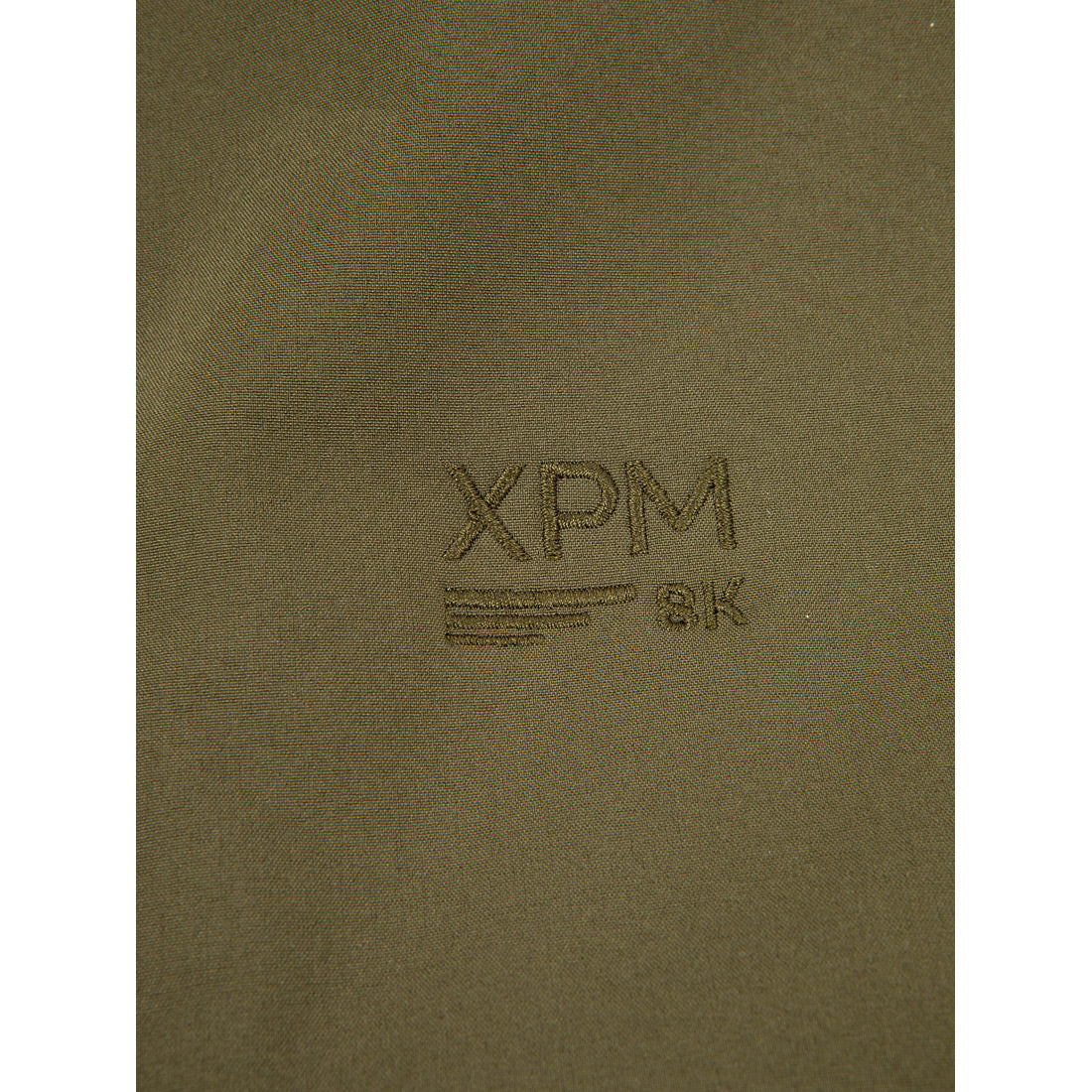 בד בצבע ירוק זית עם הדפסים של "Puffin X II", "XPM 8K" ושלוש פסים אופקיים, כולם רקומים בחוט תואם. מותג: Aztec.