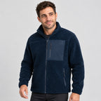 גבר לבוש במעיל Aztec Blizzard Sherpa Full Zip בצבע כחול כהה, עם רוכסן מלא, גימור מרקם וכיס חזה עם רוכסן.