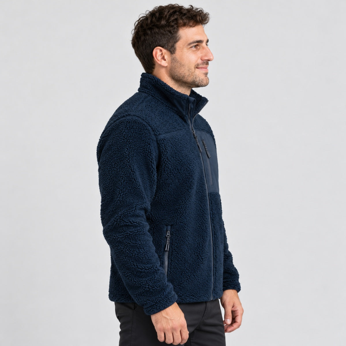 גבר הלובש מעיל Aztec Blizzard Sherpa Full Zip בצבע כחול-צי, בעל מרקם ייחודי וכיס בחזה.