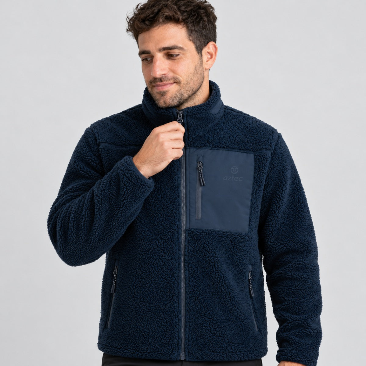 גבר לבוש בסווטשירט Aztec Blizzard Sherpa Full Zip בצבע כחול כהה, הכולל רוכסן מלא, גימור מרקם וכיס חזה עם רוכסן.