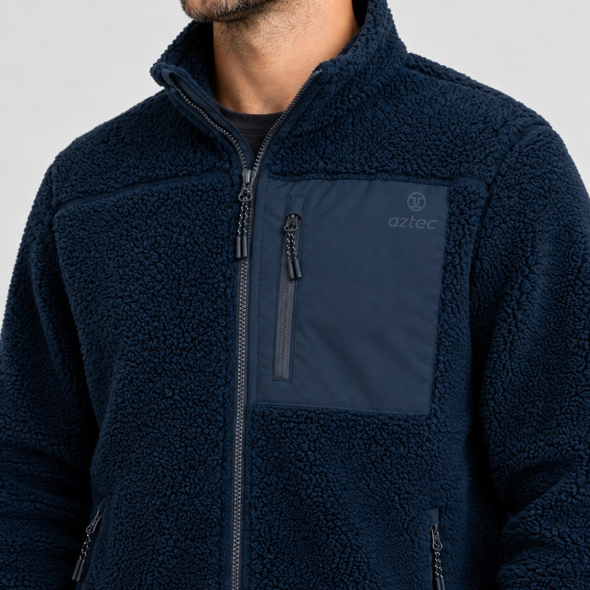 מעיל Aztec Blizzard Sherpa בצבע כחול כהה עם רוכסן מלא וכיס חזה בצבע מנוגד.