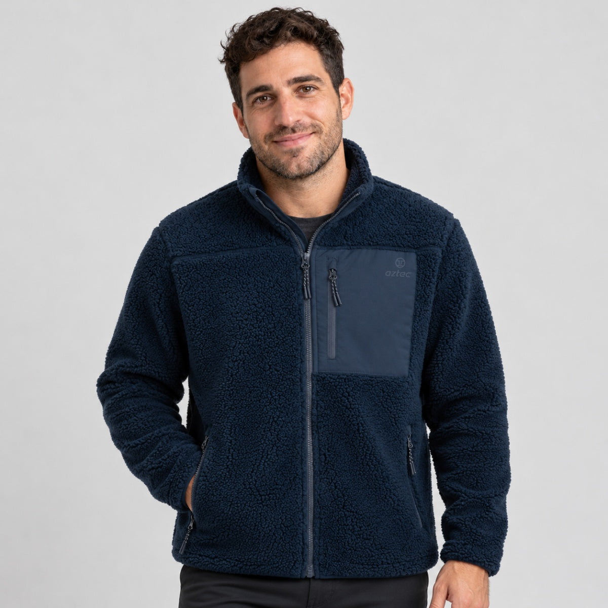 גבר לובש מעיל פליס Aztec Blizzard Sherpa Full Zip בצבע כחול כהה עם מרקם, בעל רוכסן מלא וכיס חזה עם רוכסן.