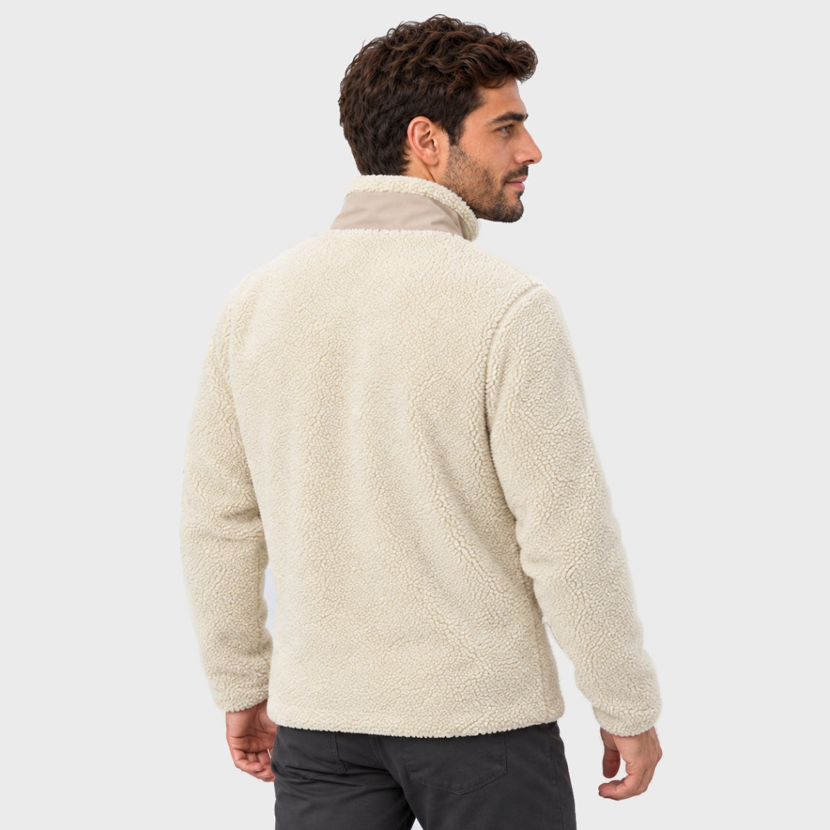 גבר הנראה מאחור, לבוש במעיל Aztec Blizzard Sherpa Full Zip בצבע לבן-שבור עם צווארון בצבע חום בהיר.