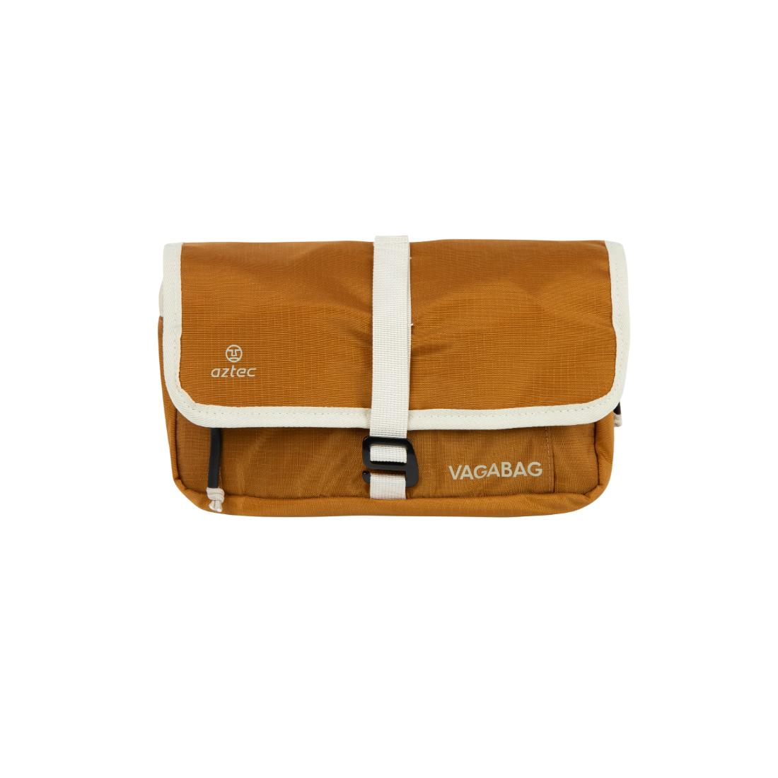 תיק כתף קטן ומלבני בצבע חום של המותג Aztec Vagabag, עם גימור ורצועה לבנים, ועליו שם המותג ולוגו Aztec האופייני מודפסים על הדש הקדמי.