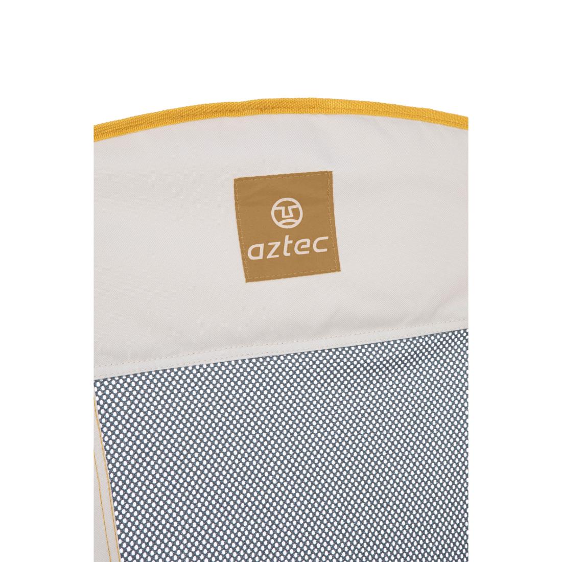 תקריב של כיסא Aztec Horizon מבית Aztec, הכולל בד בצבע בז' עם גימור בצבע צהוב חרדל, טלאי חום שעליו מוטבעים הלוגו והשם של Aztec, ורשת בדוגמת אפור-לבן בחלקו התחתון.