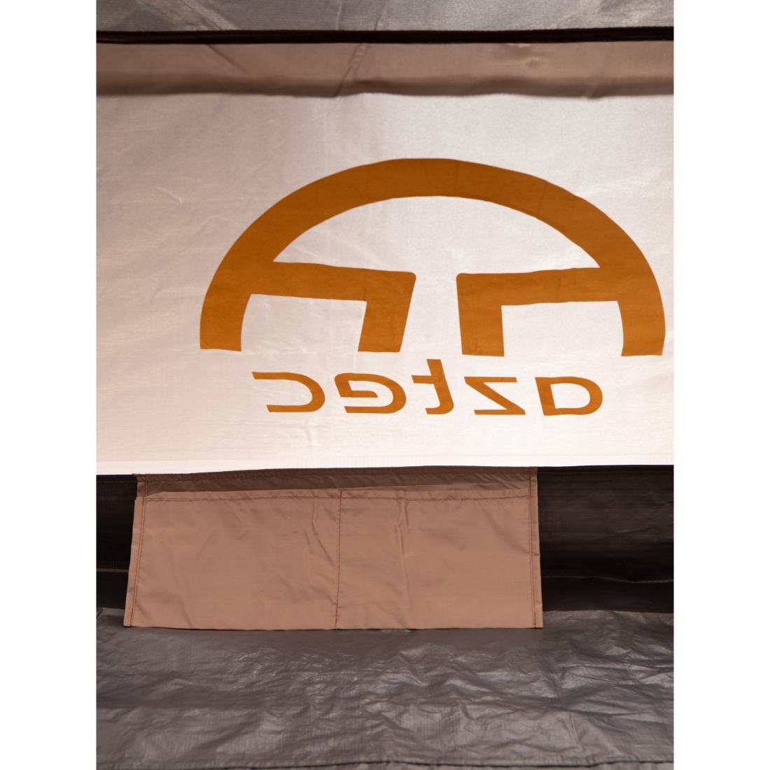 תקריב של פנים האוהל מציג דש חלון מתחת ליריעת בד לבנה שעליה מוטבעים הלוגו והשם של Aztec בהיפוך, מה שמדגיש את עיצוב ה-Aztec Element 6p Clip.