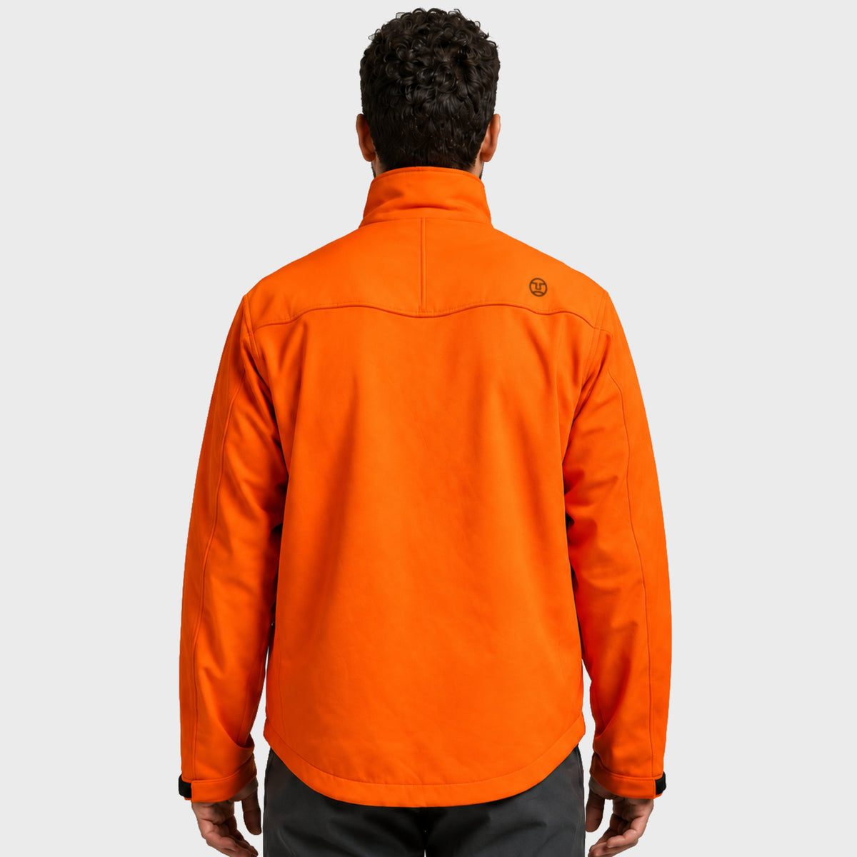מבט מאחור על אדם הלובש מעיל Softshell של Aztec Recovery בצבע כתום בוהק, עם צווארון גבוה ולוגו בחלק העליון של הגב.